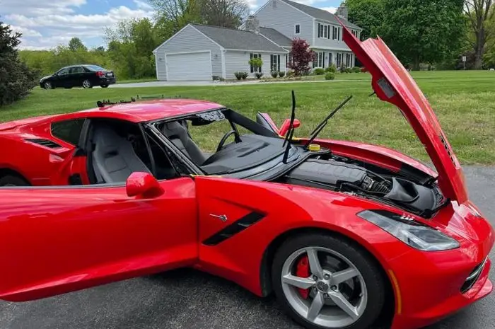 Professional auto glass technician replacing the windshield on a red Chevrolet Corvette to restore visibility, safety, and structural integrity.