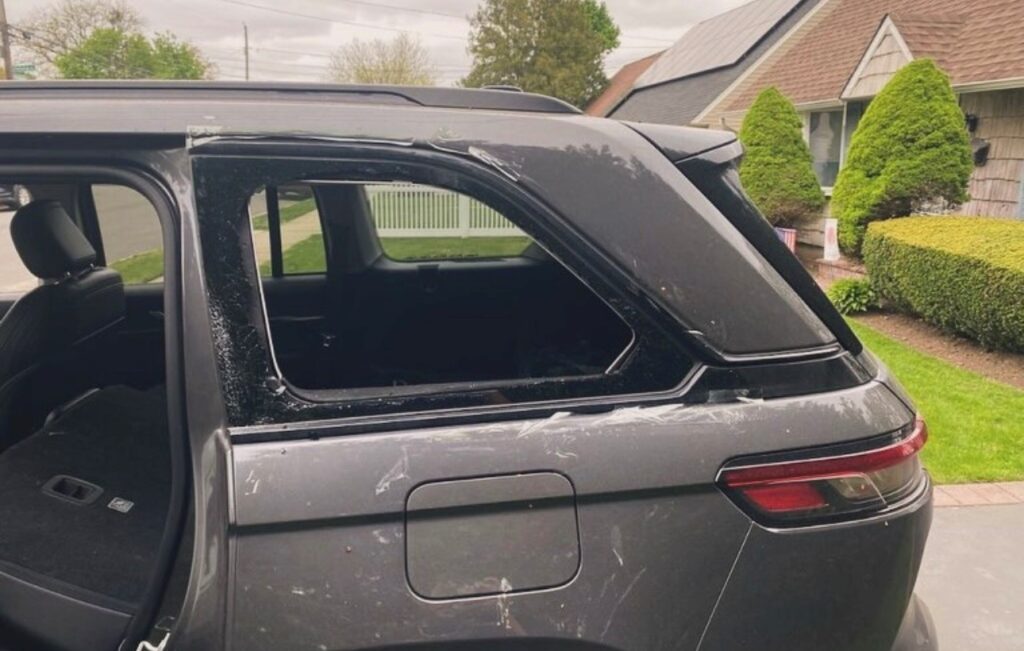 Broken rear quarter window on a gray SUV requiring professional quarter glass replacement service in Mineola, NY.